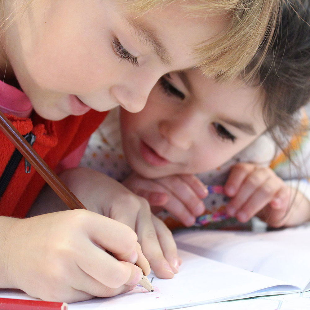 Two children coloring in book