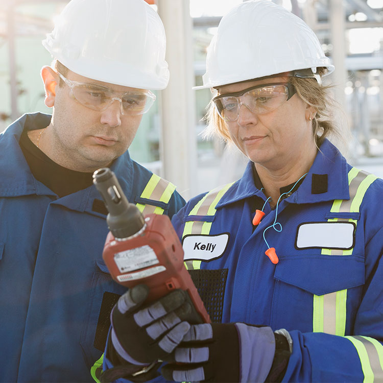 Male and female construction workers examining equipment