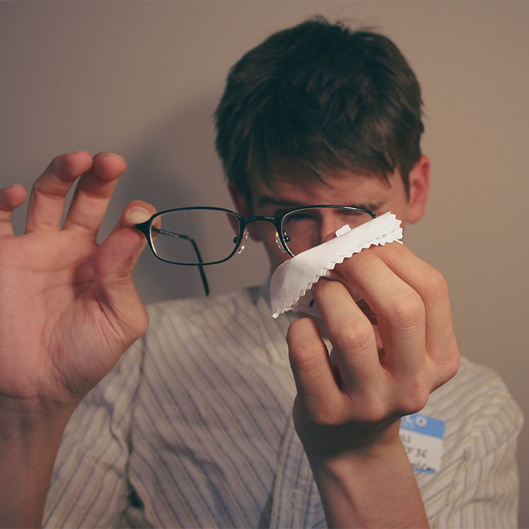 Man cleaning glasses with cloth