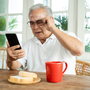 Older man struggling to see cell phone