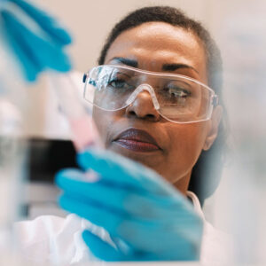 Mature female virologist wearing eyeglasses experimenting in laboratory
