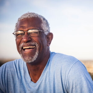 older man smiling outside